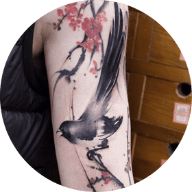 Elegant Tattoo of a Bird Among Blossoms PNG