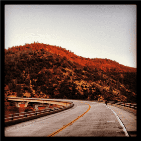 Scenic Toll Road Through Majestic Mountains PNG