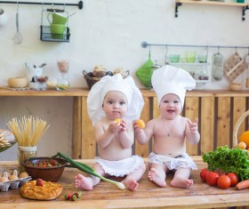 2 cook costume Baby sitting on the table Stock Photo