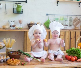 2 The cook costume Baby and kitchen food background Stock Photo