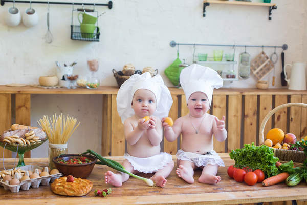 2 The cook costume Baby and kitchen food background Stock Photo