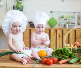 2 cook costume Baby sitting on the table and food Stock Photo