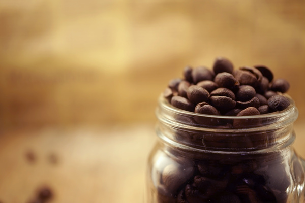A blurred photograph of a glass of coffee beans
