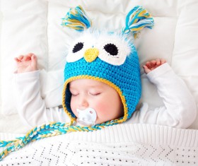 A cute baby with a cap and a pacifier Stock Photo