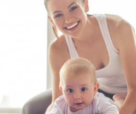 And the baby playing with the young mother Stock Photo