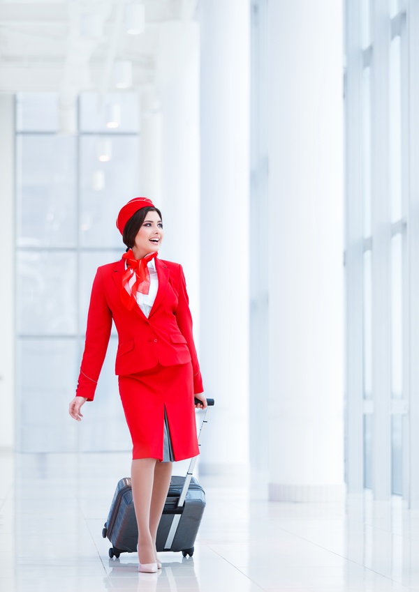 Attracting stewardess with a suitcase on white background HD picture