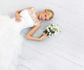 Beautiful bride lying on the floor shooting wedding photos