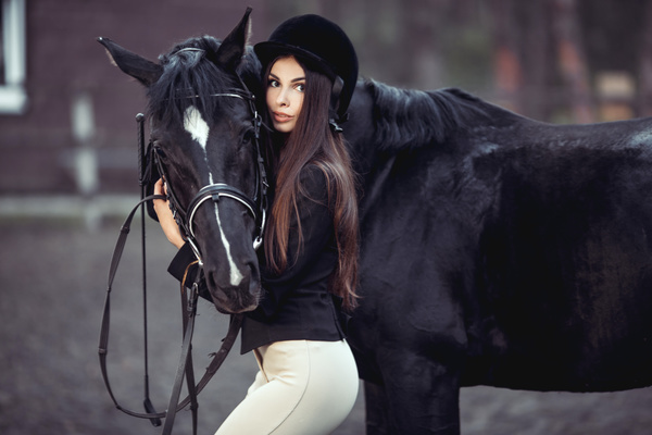 Beautiful girl and dark horse embrace