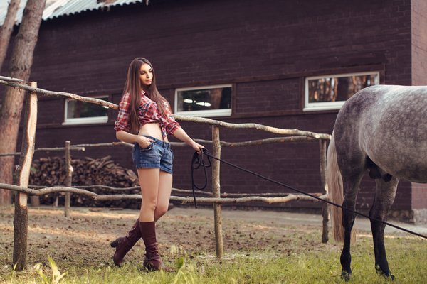 Beautiful girl holding horse and house background
