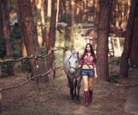 Beautiful young girl holding a white horse