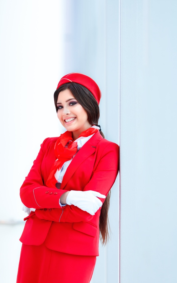 Beautiful young stewardess leaning against the wall HD picture