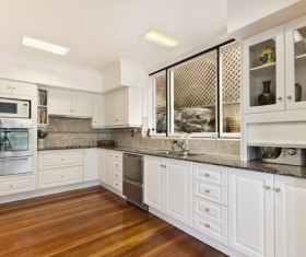 Brown floor white ceiling with white cabinetry and kitchen decor