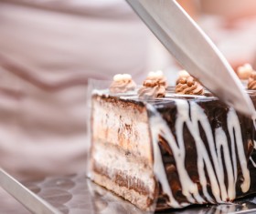 Cake maker cuts creamy chocolate cake 01