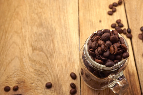 Desktop glass container with coffee beans Photo