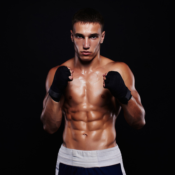 Fighter boxer standing staring strong on black background