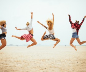Four young girls jumping on the beach Stock Photo