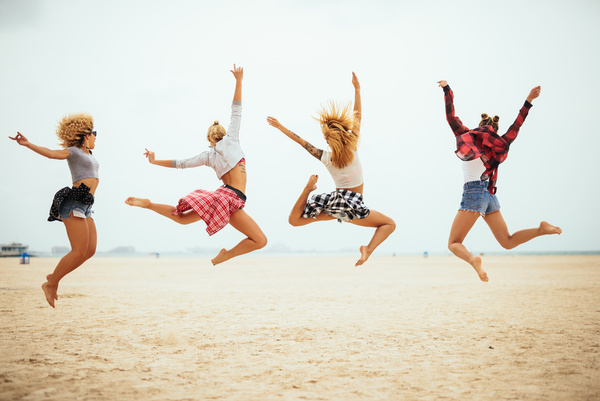 Four young girls jumping on the beach Stock Photo