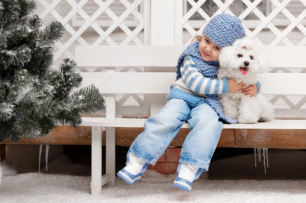Girl sitting on a bench with white puppy Stock Photo