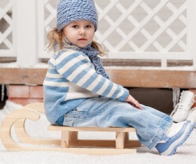 Girl sitting on a sled in winter Stock Photo