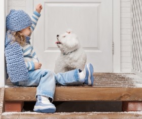 Girl sitting on the promenade playing with the puppy Stock Photo