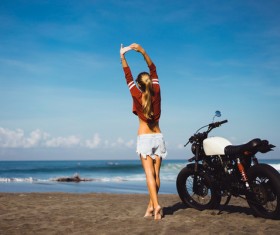 Girl stretching with arms and motorcycle Stock Photo