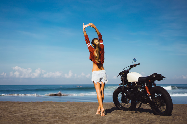 Girl stretching with arms and motorcycle Stock Photo
