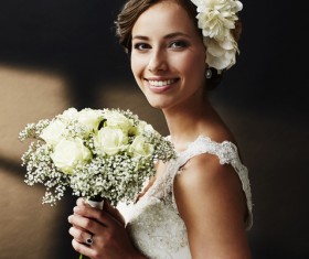 Hand-held bouquet of smiling young beautiful bride