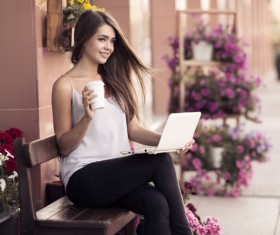 Hand holding coffee and computer Smiling young girl