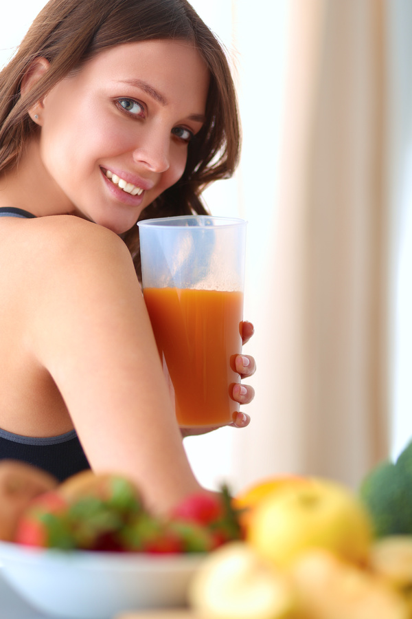Hand holding vegetable juice Smiling young beautiful woman turning
