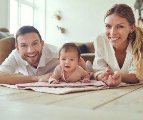 Happy family of three lying on the floor