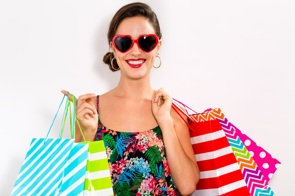 Happy woman holding shopping bags on white background