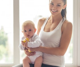 Holding a yellow dumbbell baby sitting in her arms Stock Photo
