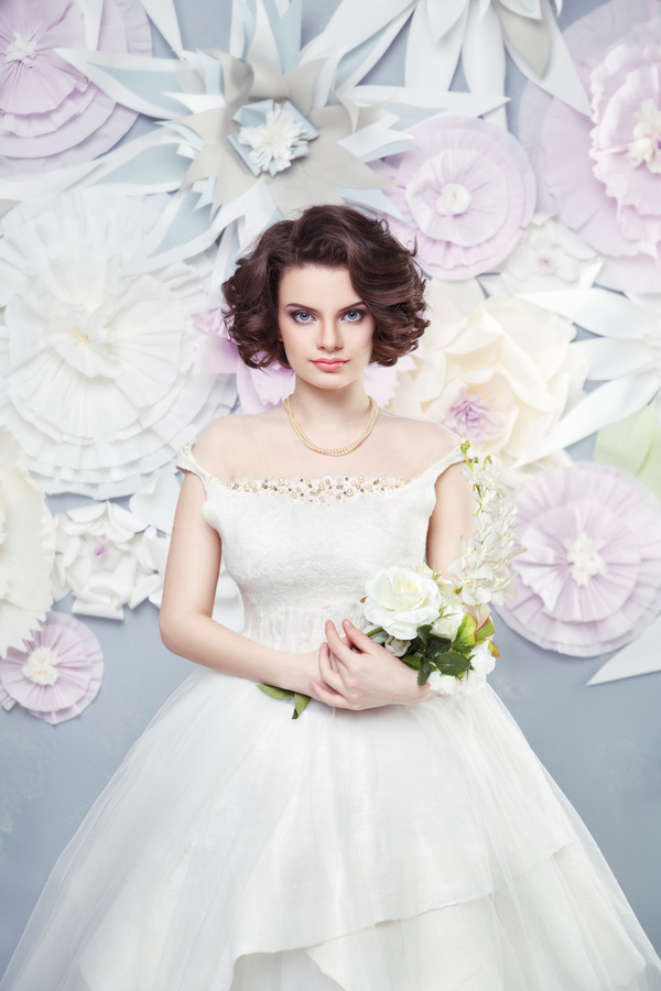 Holding flowers Happy woman wearing wedding dress with fake background