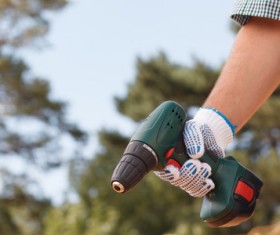Man holding drill with blurred background HD picture
