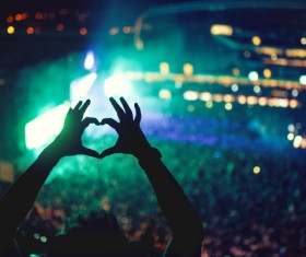 Music concert with lights and silhouette of a man partying heart