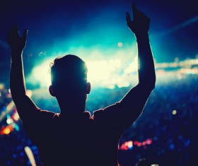 Music festival holding hands with bright man in the background