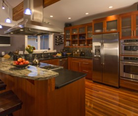 Open kitchen brown cupboard with fruit flowers and wine