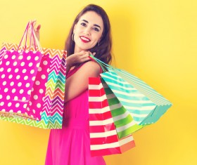 Happy young woman holding many shopping bags