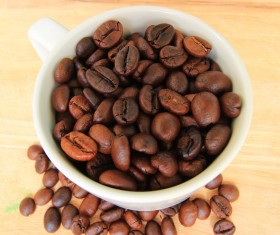Small bowl of coffee beans wooden desktop photo