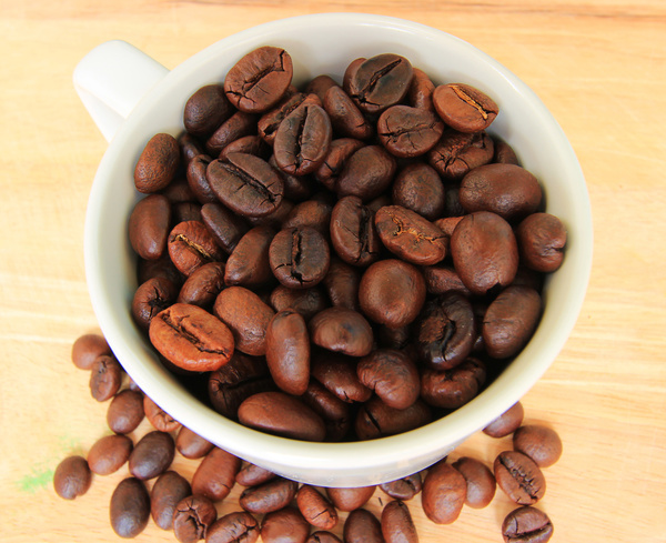 Small bowl of coffee beans wooden desktop photo