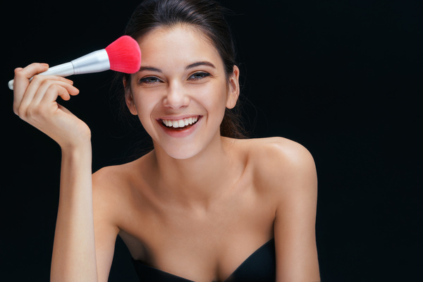 Smiling woman with foundation brush