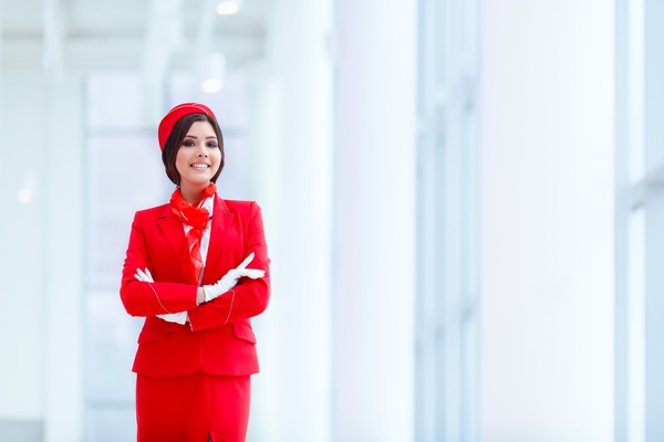 Smiling young beautiful flight attendant with a white background Stock Photo