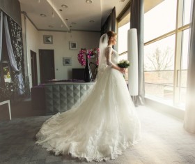 Standing at the window wearing a beautiful wedding bride