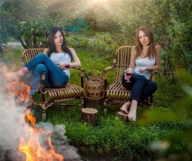 Summer holidays and vacation - girls with red wineglasses near bonfire