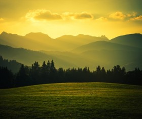 Sunset over the mountains and meadows Stock Photo