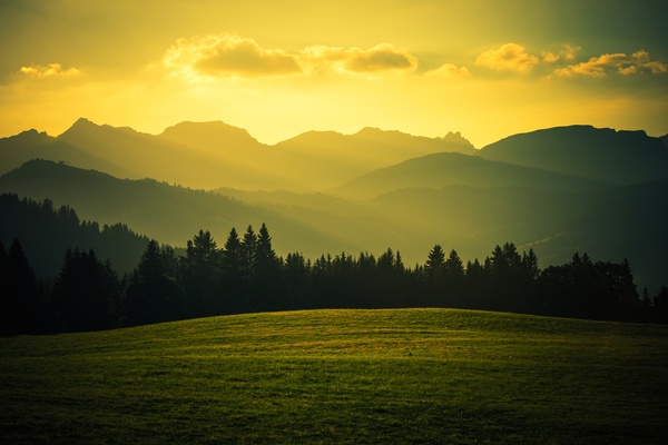 Sunset over the mountains and meadows Stock Photo