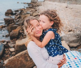 The little girl kissed her mother on the cheek