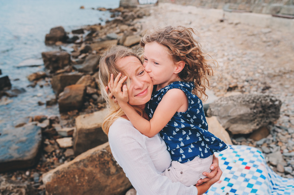 The little girl kissed her mother on the cheek