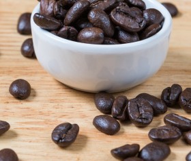 Wooden desktop with coffee beans and white bowl background