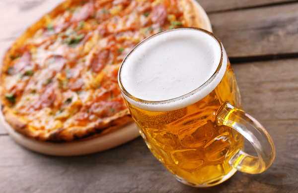 Wooden pizza on the table with beer Stock Photo